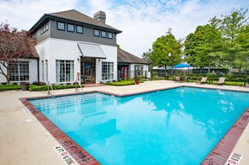 A swimming pool with a white building in the background